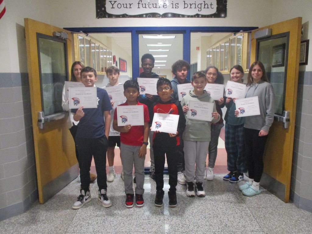 A group of middle school students pose with certificates in a hallway below a sign that says "Your future is bright."