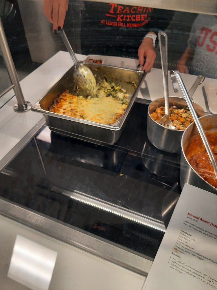 New dishes, including pastel azteca, roasted vegetables, and stewed beans rest on a counter top for Food Services employees to taste after a training.