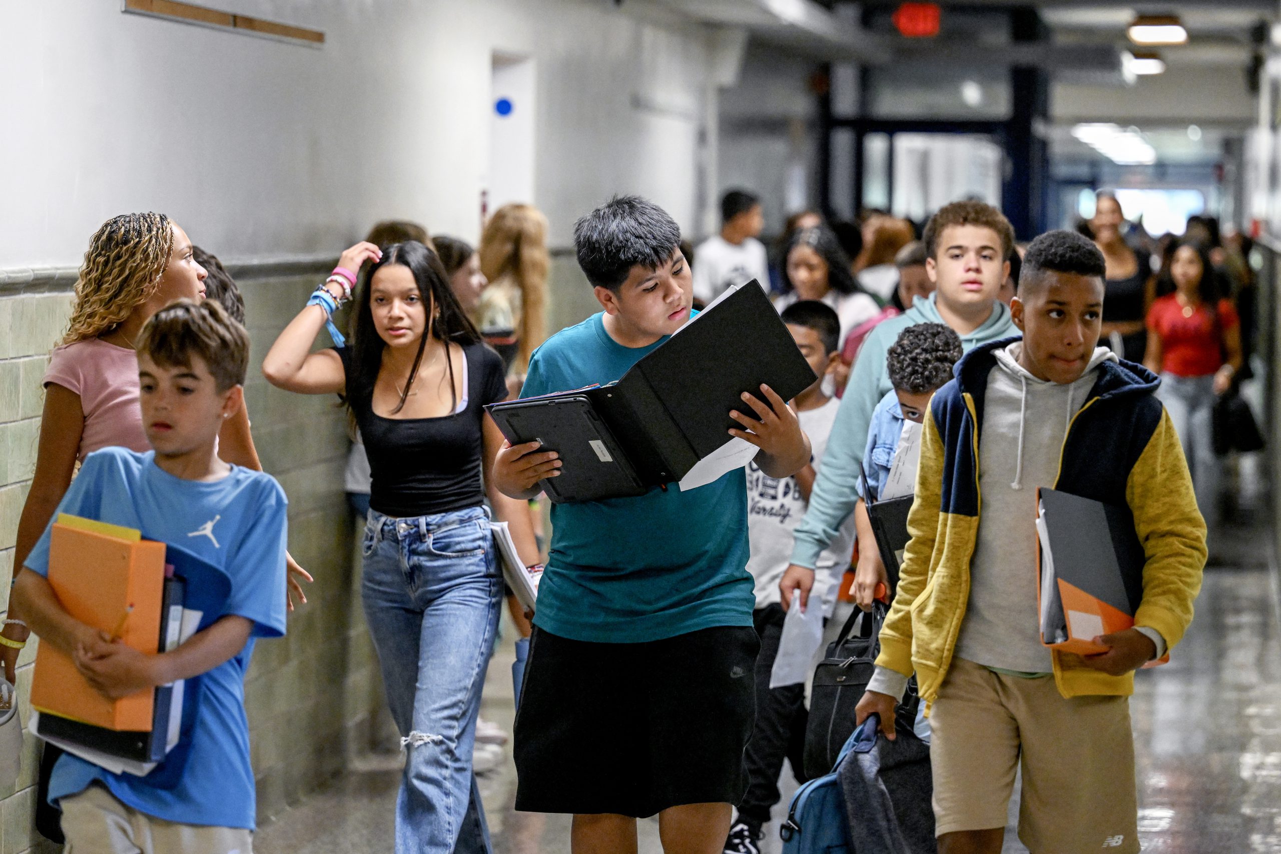 Junior high school students walking in the school hallway between classes