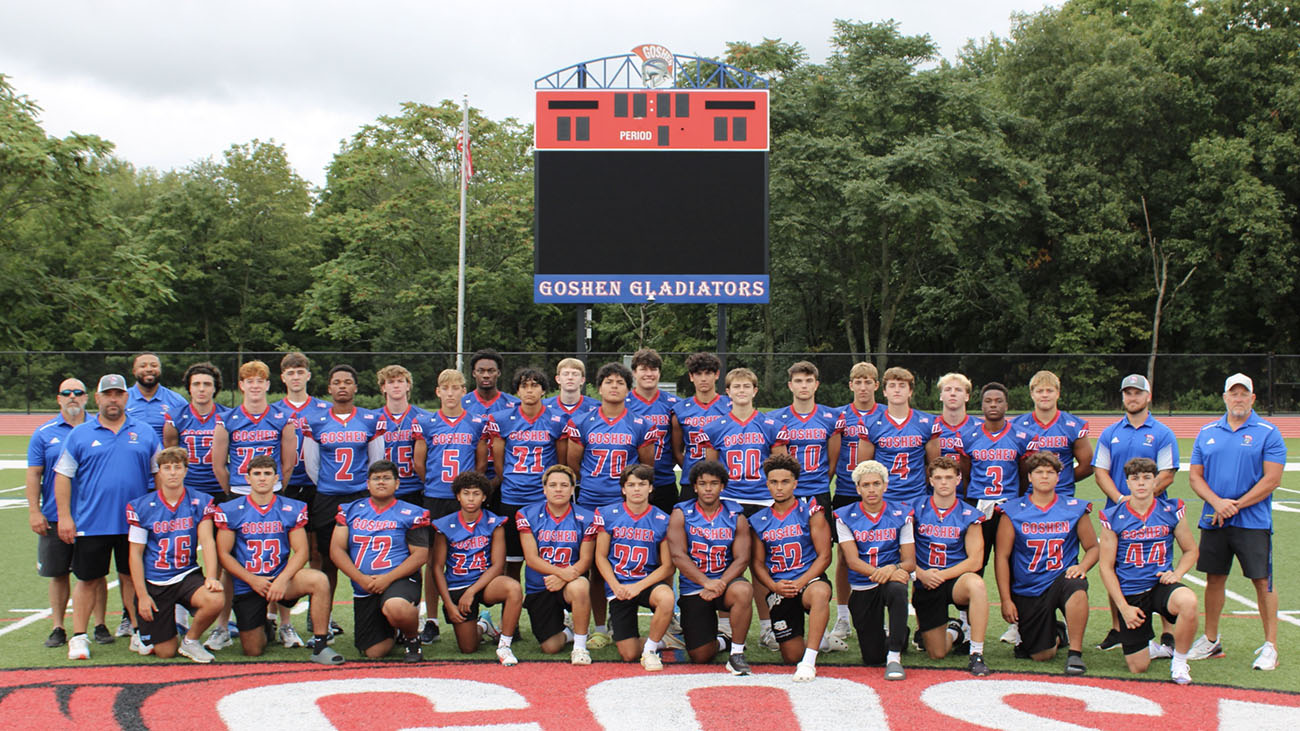 Football team poses on turf field