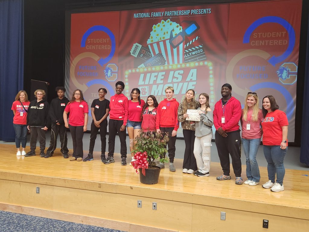 Goshen students and staff standing on stage for the ceremonial passing of the bush at Red Ribbon Week in Chester Academy. 