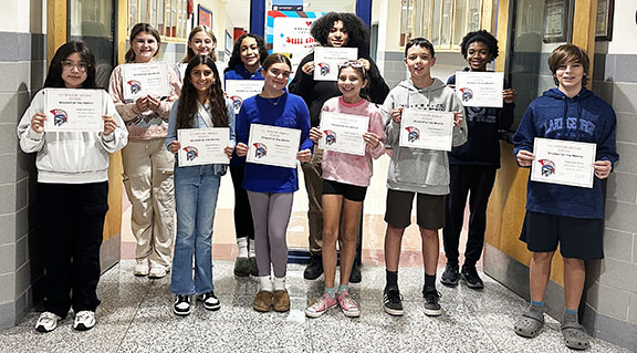 A group of smiling students holding certificates declaring them as Students of the Month for September 2024.