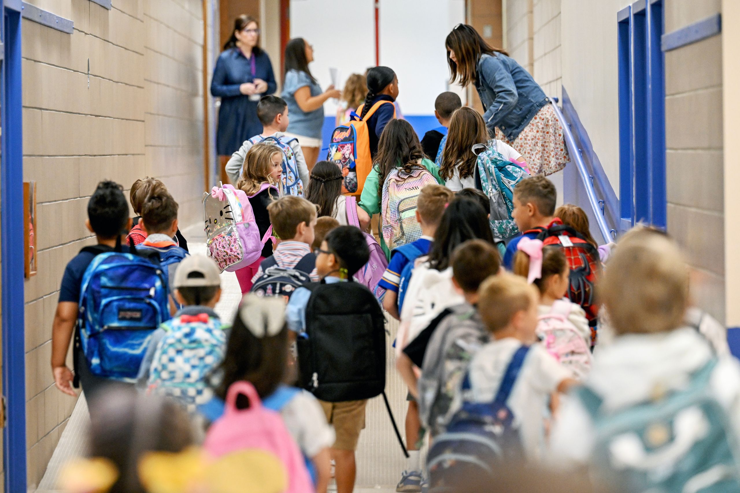 The hallway is filled with students on their way to class on the first day of school. 