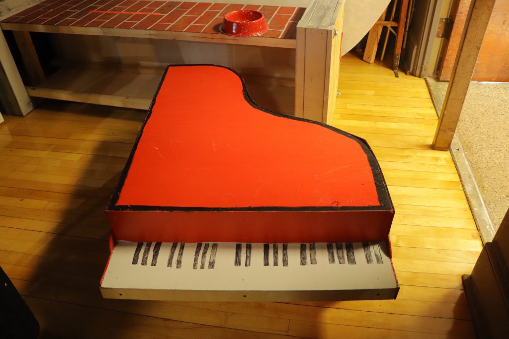 The dog bowl for Snoopy and the piano used in the play backstage at C.J. Hooker middle school. 