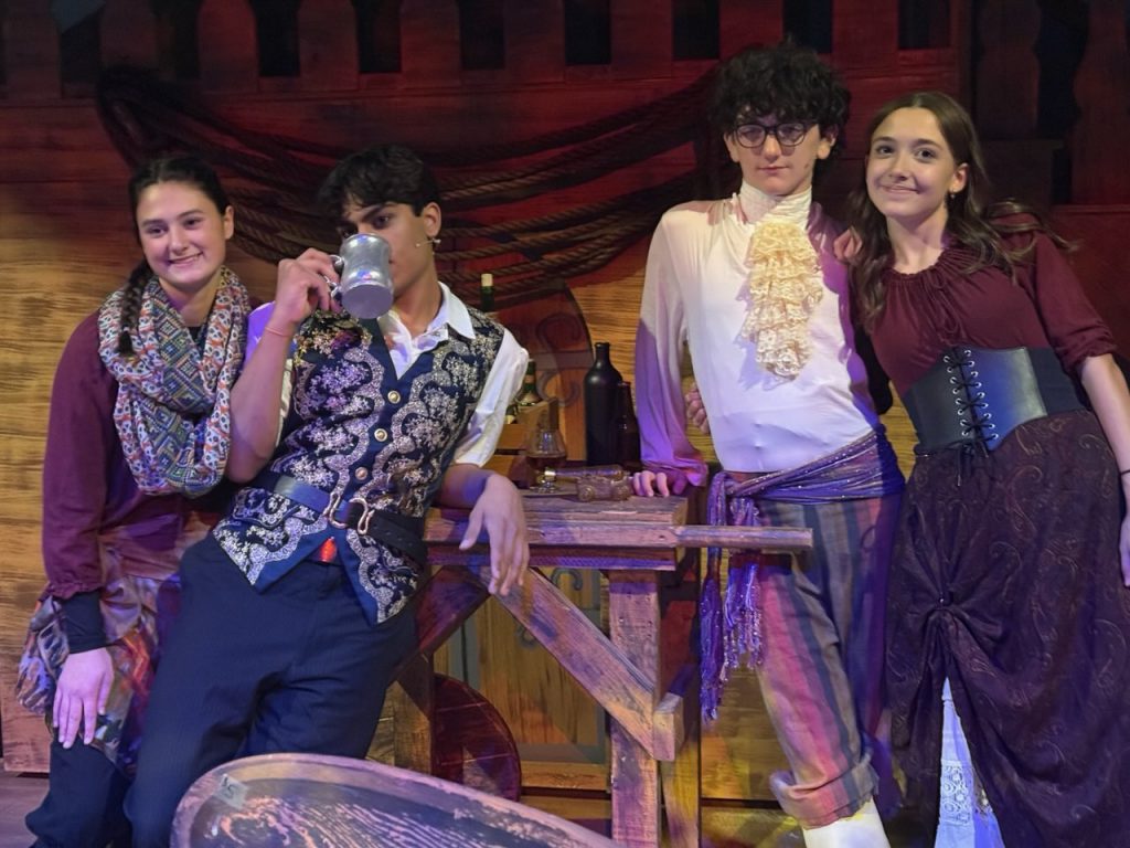 Four students pose on the set of Treasure Island in full costume. From left to right: Gwen Warland, Dhilan Tawil, Nick Obligado, Emily Loftus.