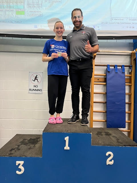 Kaylee Croughan and Dr. Voloshin stand at the top of the winners' podium to celebrate a Section 9 championship.