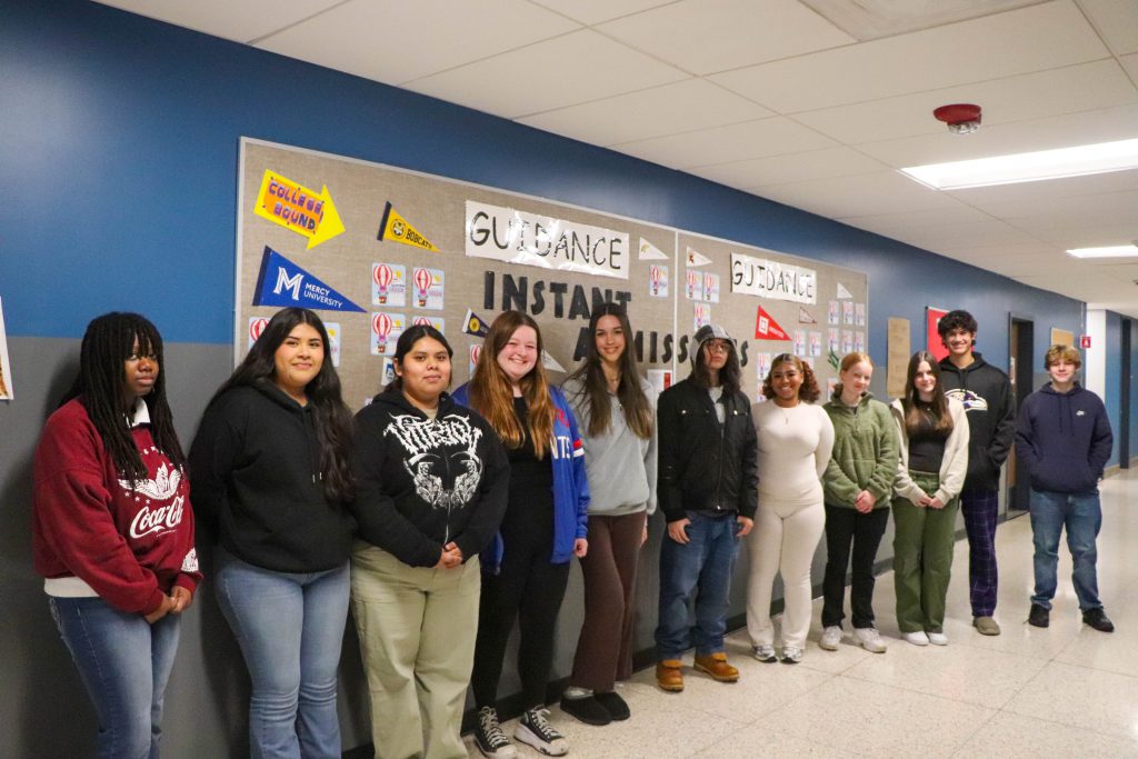 Students that participated in Instant Decision Day 2024 stand in front of the "Instant Admissions" board in the Goshen High School hallway. 