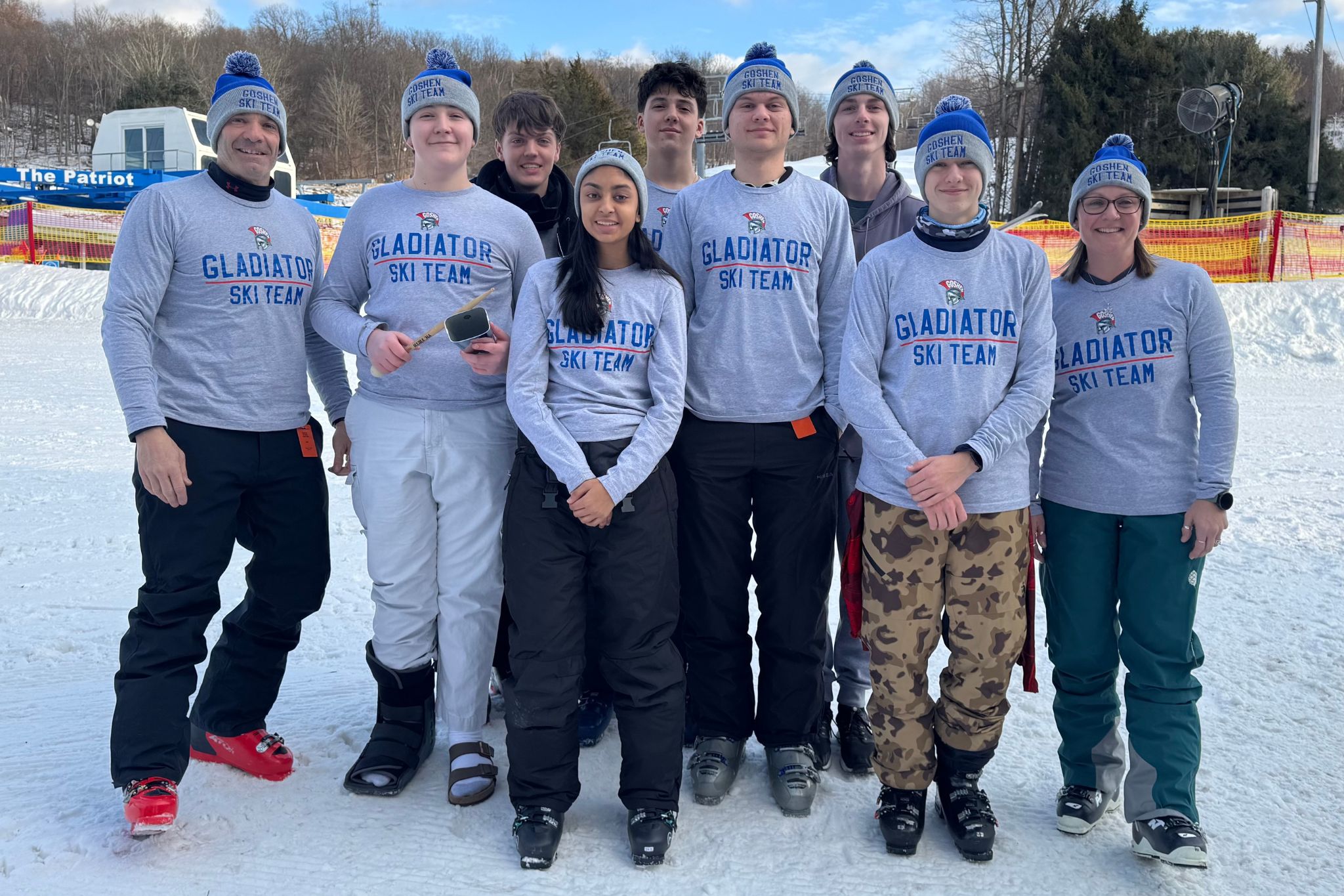 Goshen's alpine ski team poses for a picture. The athletes are wearing longsleeve shirts with "Gladiator Ski Team" written on them.  