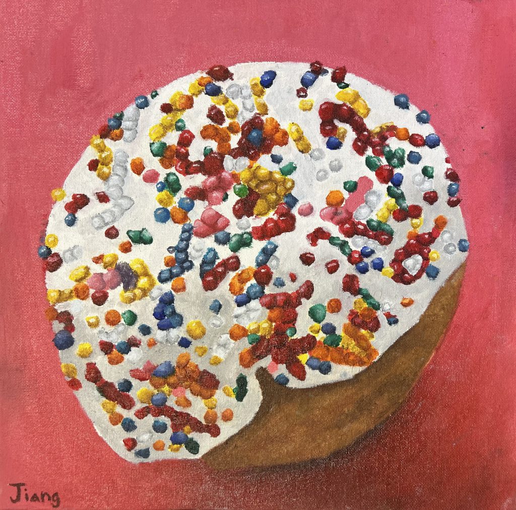 A donut with sprinkles in front of a red background. 