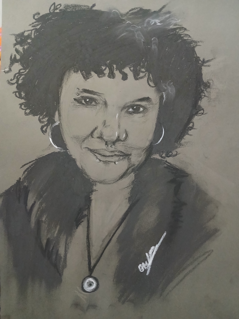 A black and white self portrait of a girl with earrings, a necklace, and curly hair in front of a gray background. 