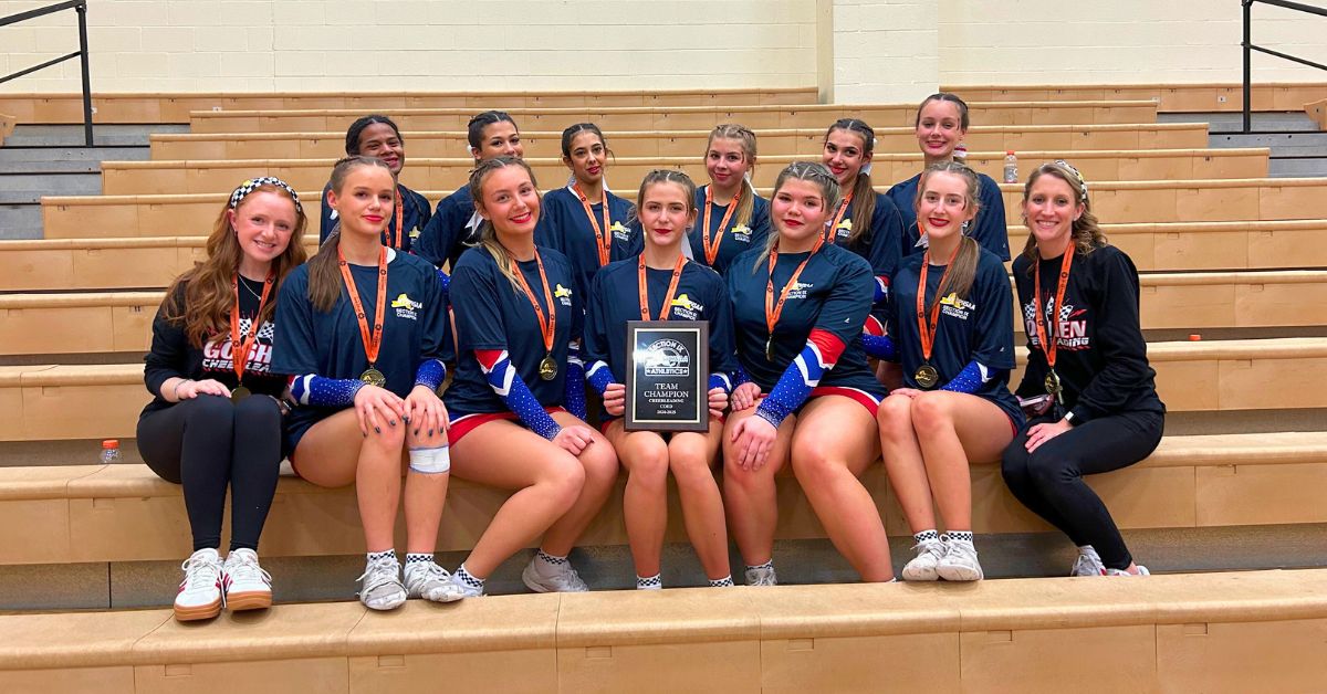 The entire Goshen cheer team poses with their championship award on bleachers after winning section 9.