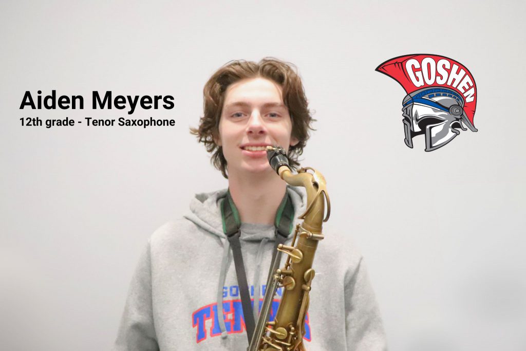 Aiden Meyers smiles for the camera with his saxophone. The photo has his name along with 12th grade tenor saxophone written on it and the Goshen Gladiators' helmet logo. 