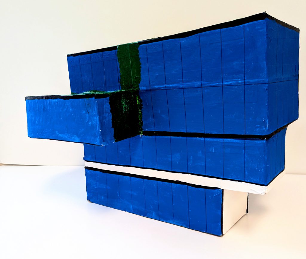 This design has lines vertical and horizontal over a blue box. There are thick black lines separating the boxes. The picture is taken in front of a white background. 