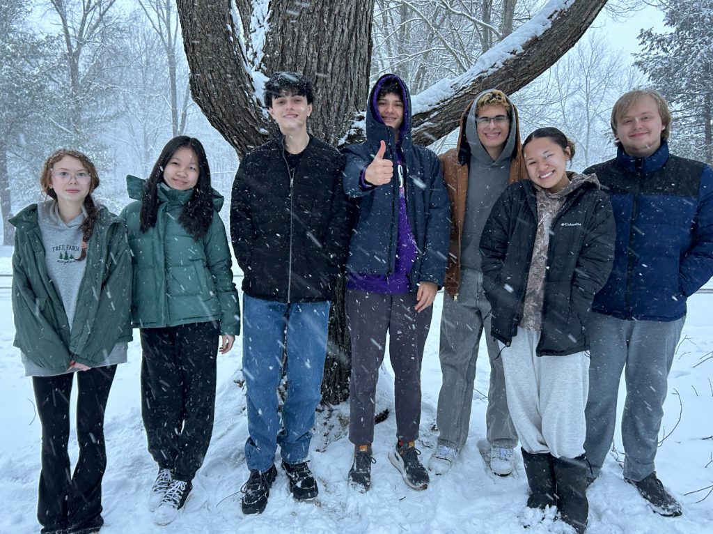 Team Seligman is standing outside in the snow. They are all smiling and looking at the camera. 